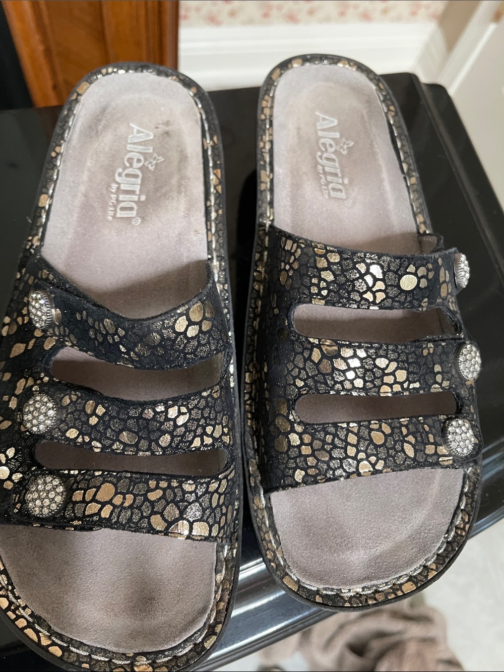 Alegria Black and Gold Patterned Slip-On Sandals